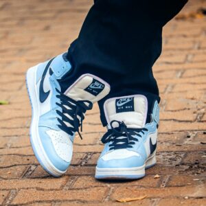 Close-up of fashionable blue and white Nike sneakers on a brick path, showcasing modern street fashion.